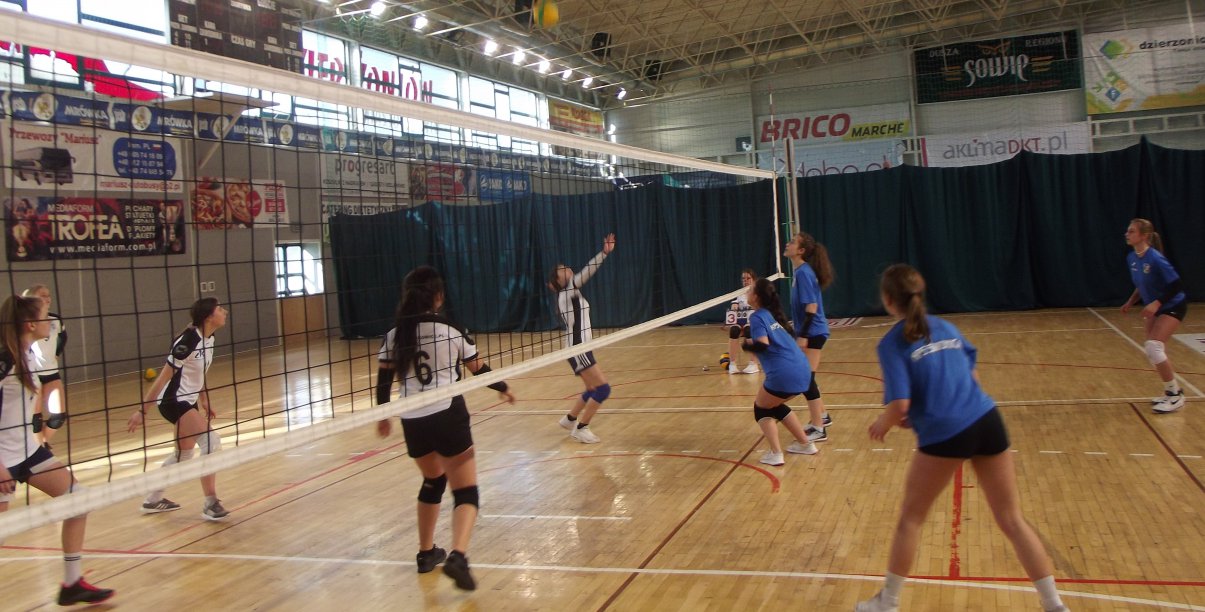 Dziewczyny grające w siatkówkę w hali sportowej 