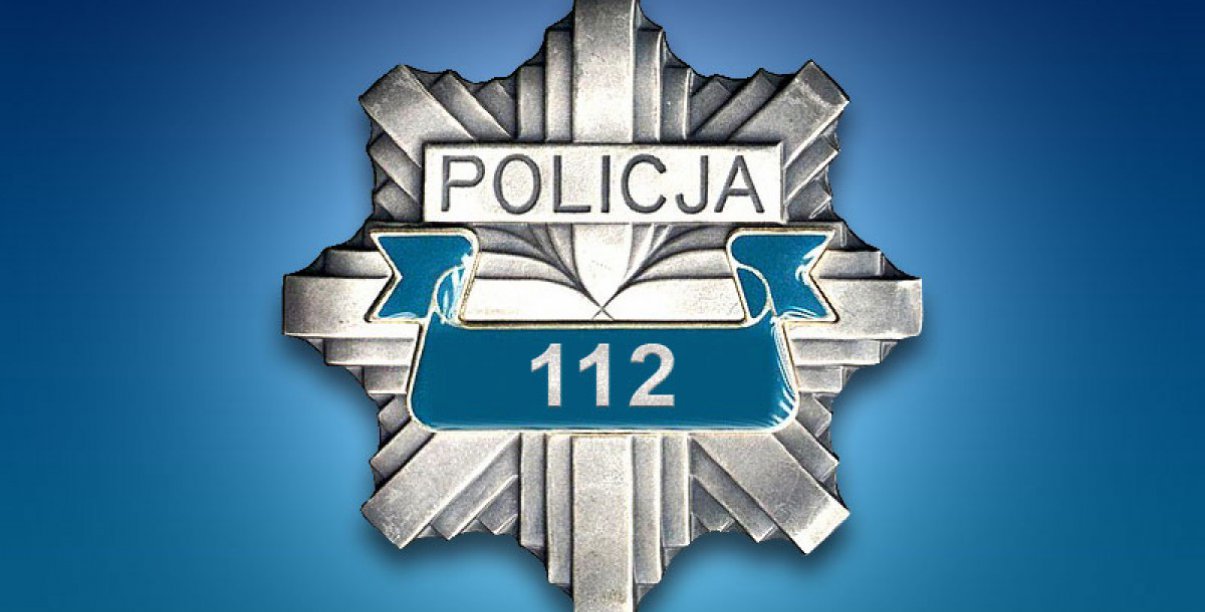 Odznaka z napisem Policja i numerem 112, na niebieskim tle