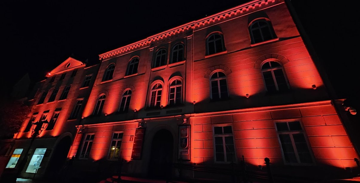 Ściana budynku ratusza z bliska, podświetlona na czerwono