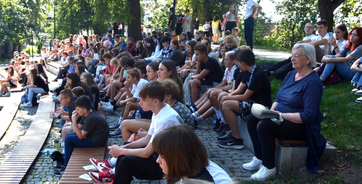 Młodzi ludzie siedzący na ławkach amfiteatru w parku