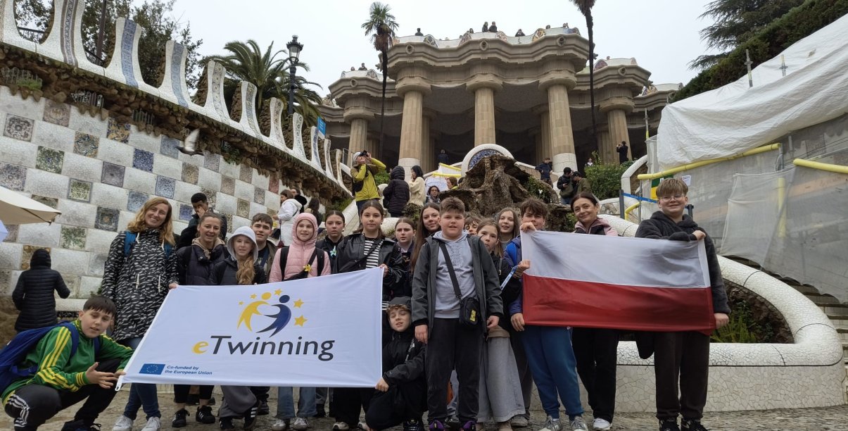 Grupowe zdjęcie uczniów, cześć z nich trzyma dużą flagę Polski