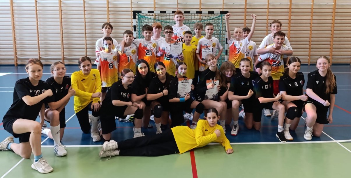 Grupowe zdjęcie uczniów szkoły w sportowych strojach w sali gimnastycznej