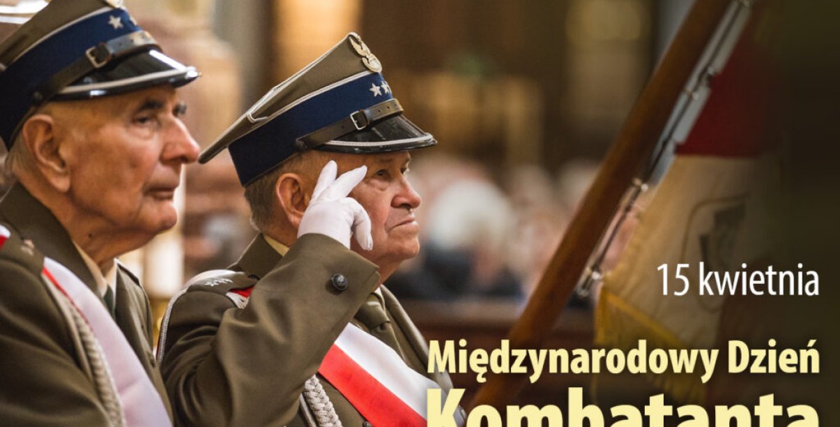 Dwóch kombatantów w mundurach salutuje trzymając sztandar
