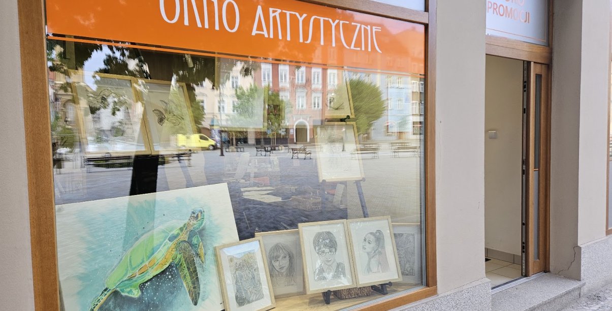 obrazy umieszczone w witrynie biura promocji