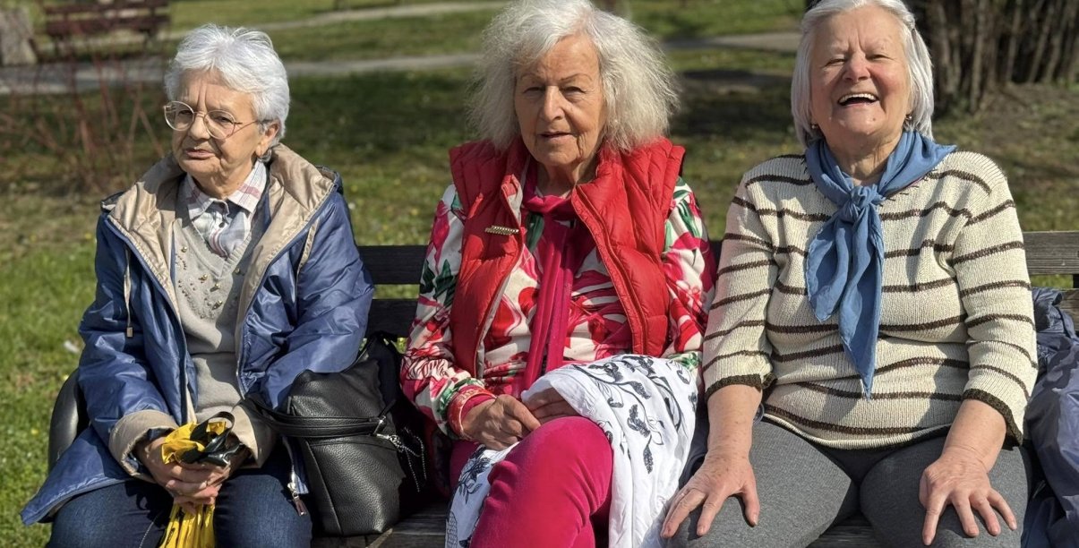Trzy seniorki siedzącce na ławce w parku