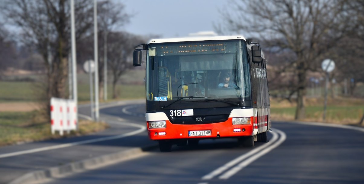 Jadący drogą pomiędzy miastami autobus komunikacji miejskiej od przodu