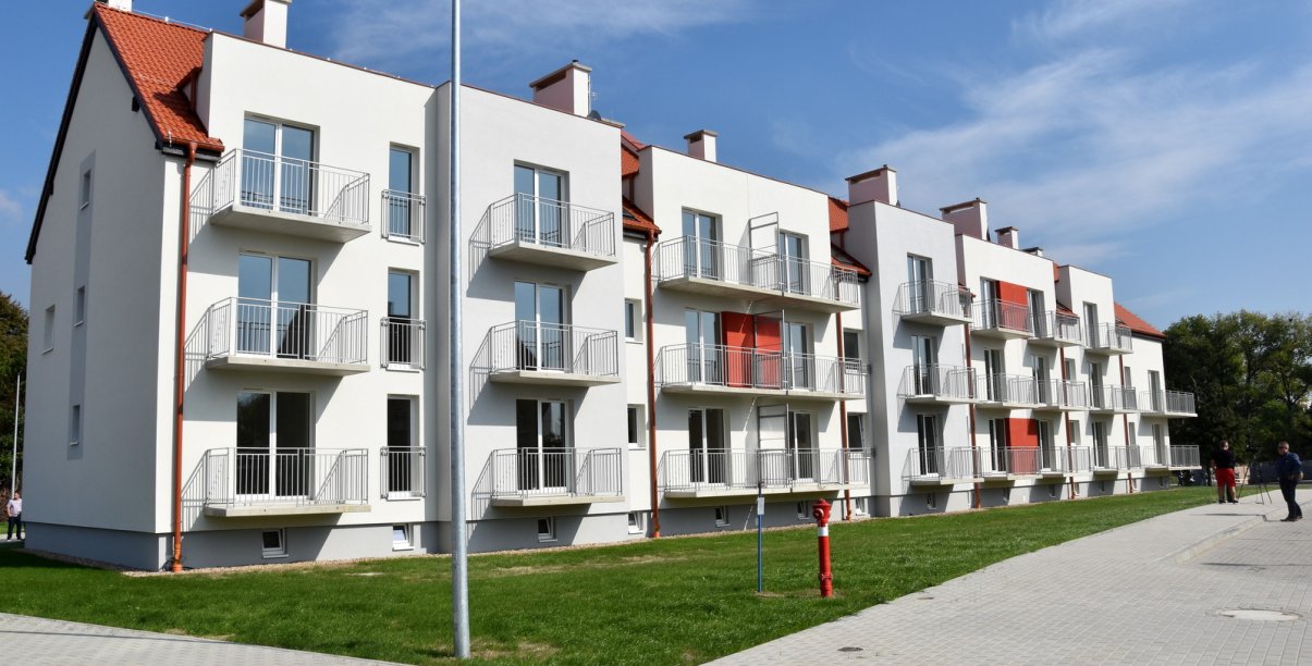 Trzypiętrowy budynek mieszkalnyz białą elewacją