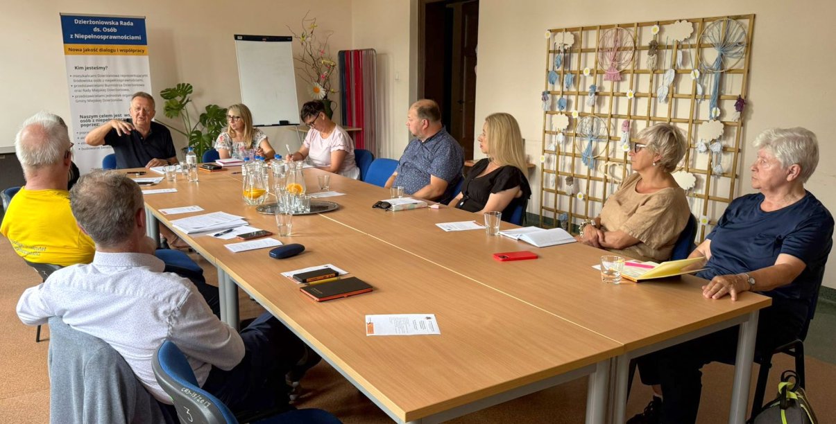 Dziesięć osób w różnym wieku siedzących przy dużym stole