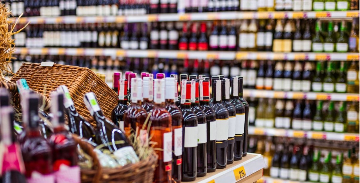 sklep z alkoholem, na półkach stoją rzędy butelek w różnych kolorach