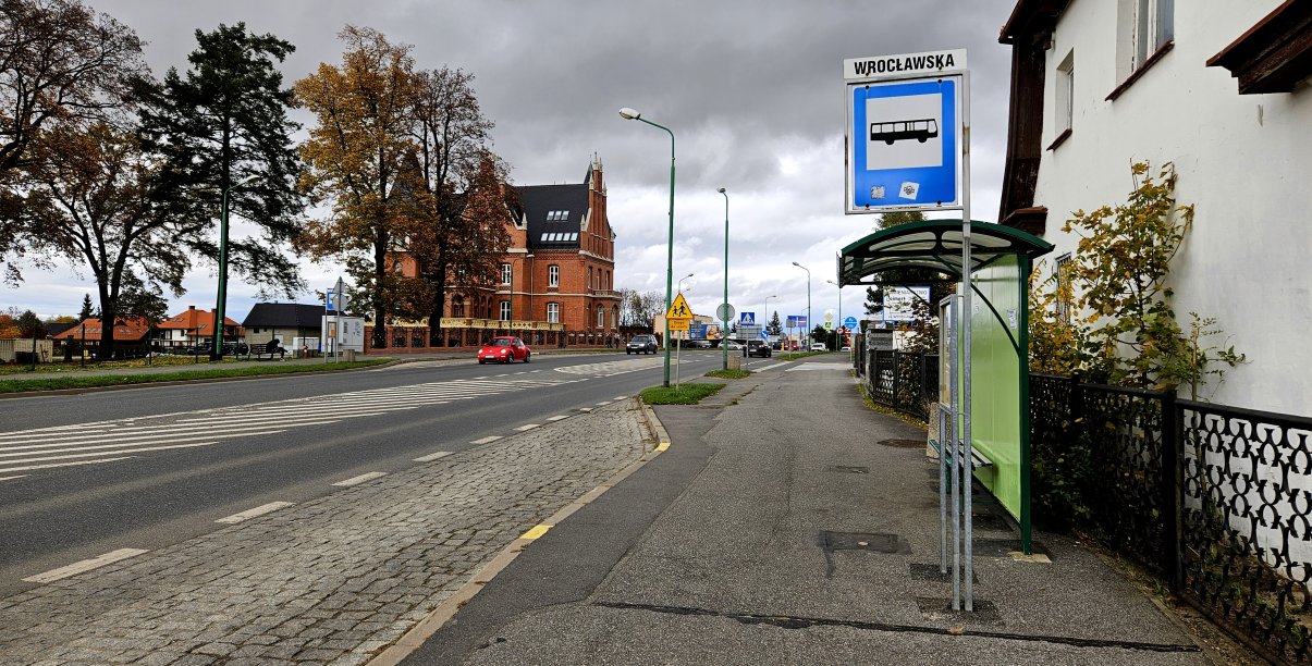 Ulica Wrocławska z widocznym po prawej stronie przystankiem autobusowym