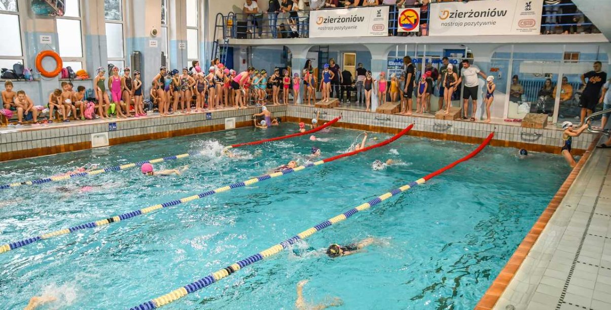 Basen kryty, dokoła ludzie kibicujący pływakom