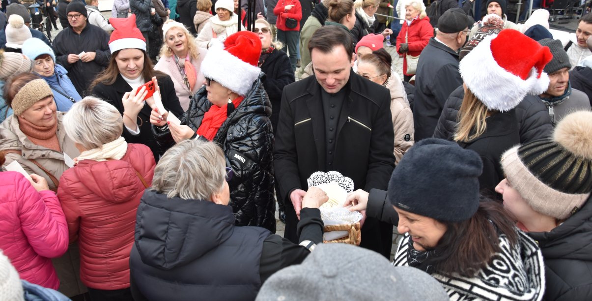 Wigilia miejska, ludzie dzielący się opłatkiem