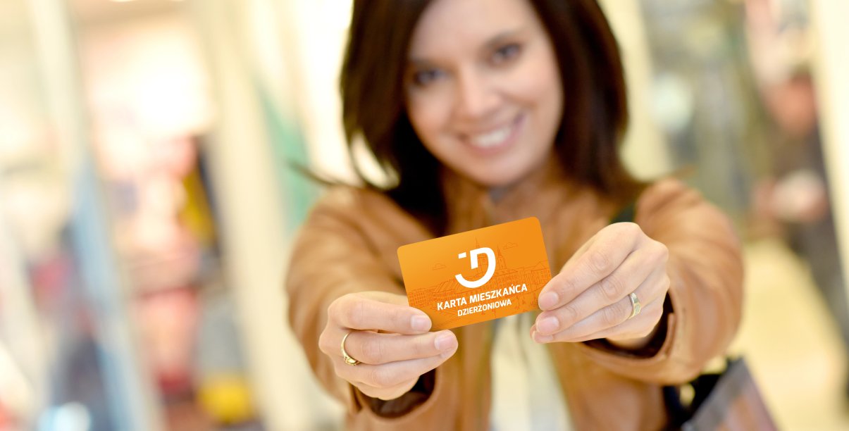uśmiechnnięta kobieta trzyma w rękach kartę meiszkańca Dzierzoniowa
