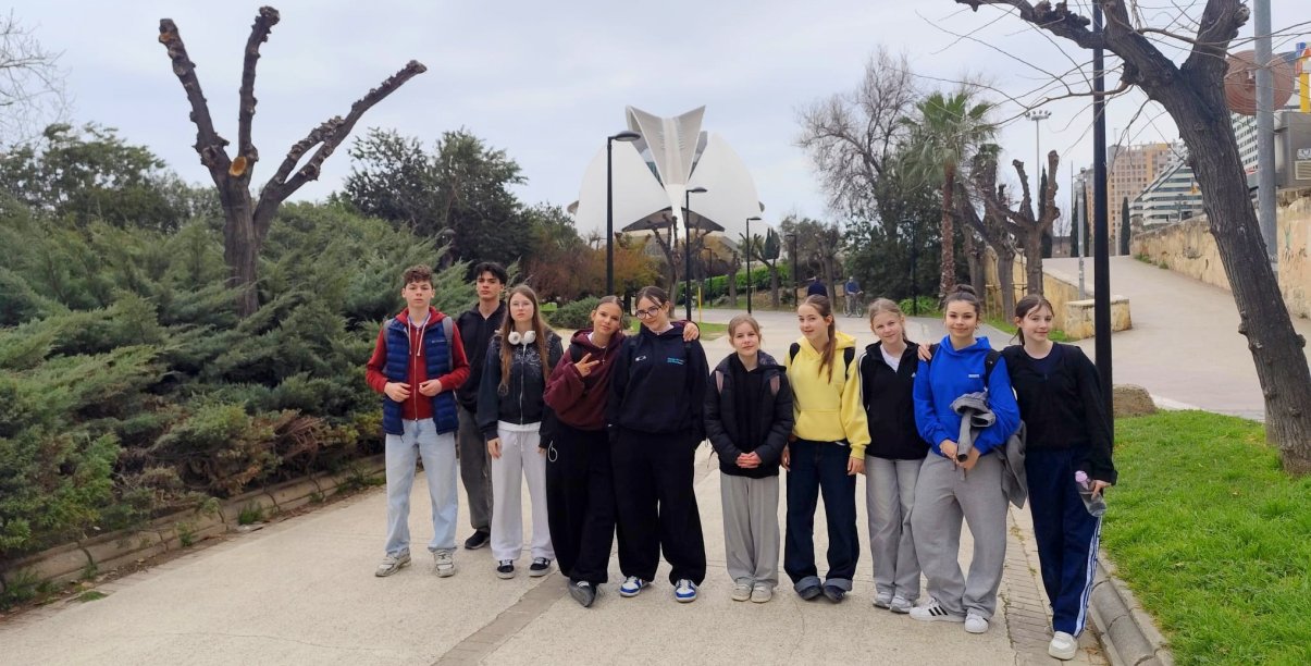 10 uczniów SP 9 na deptaku, w tle futurystyczny budynek