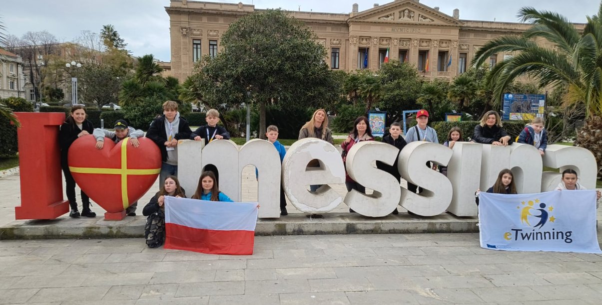 Duże litery I love Messina na tle miasta, przy literach stoją dzieci