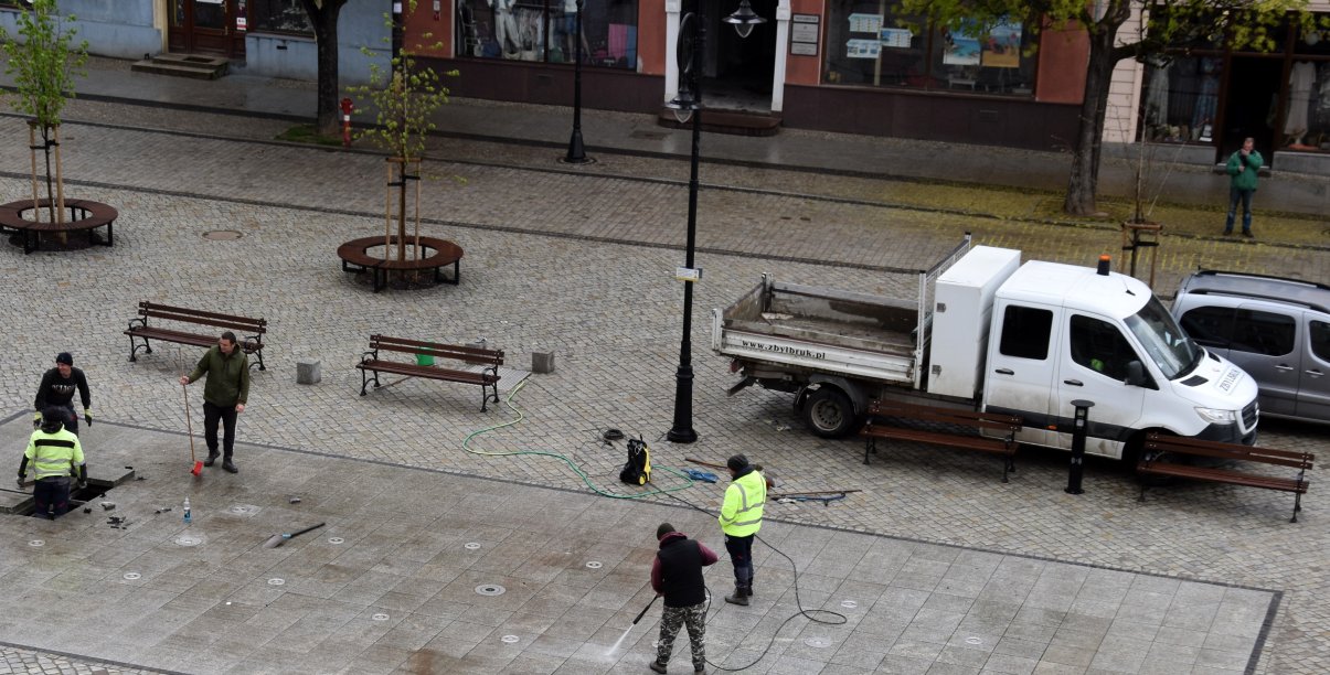 Pięciu pracowników czyści i sprawdza fontannę posadzkową
