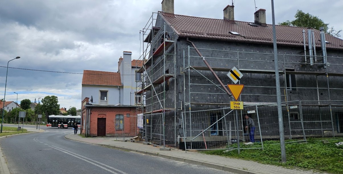 Dom wielorodzinny, rusztowania, elewacja w budynku obłożona szarym styropianem