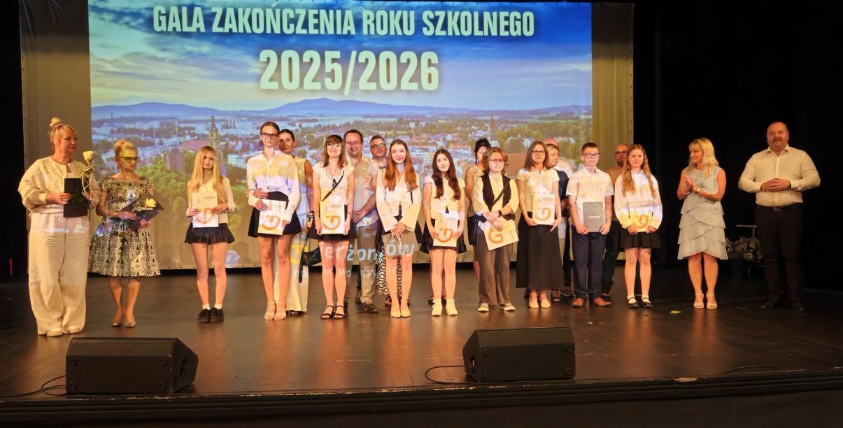 Kilkunastu uczniów z dyplomami na scenie