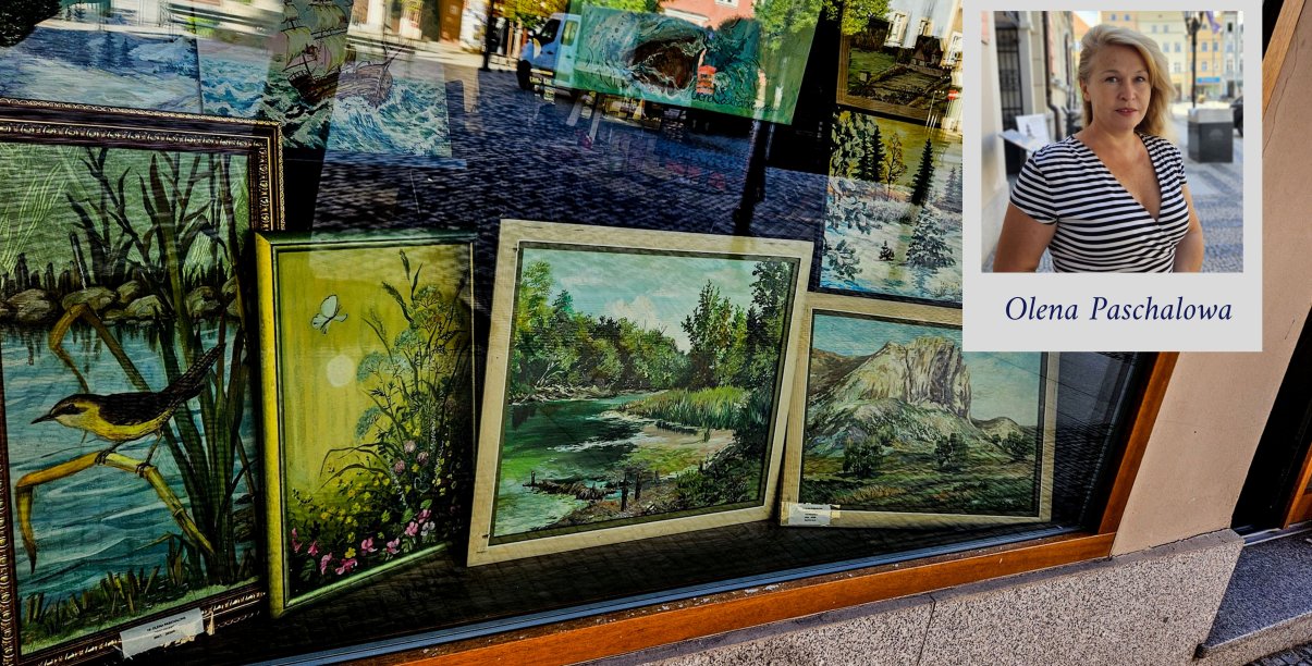 Witryna okienna z obrazami przedstawiającymi naturę i zdjęciem autorki