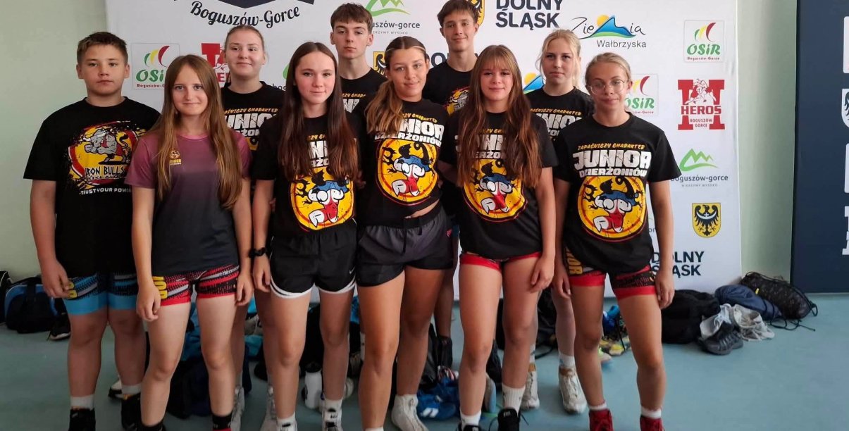 Zawodniczki i zawodnicy w klubowych czarnych koszulkach na grupowym zdjęciu