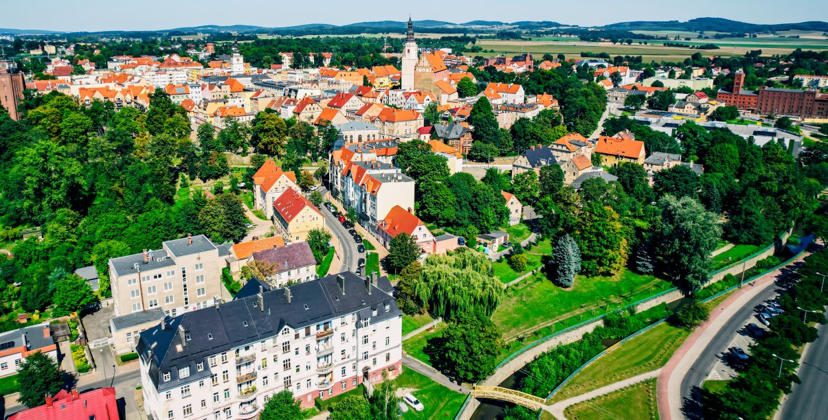 Fragment Dzierżoniowa z lotu ptaka w tle góry
