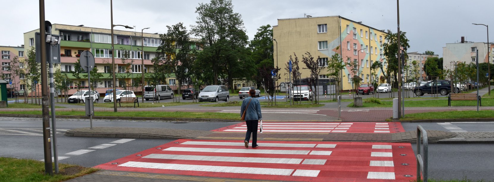 Widok przejścia aktywnego z przechodniem, na drugim planie budynki os. Kolorowego