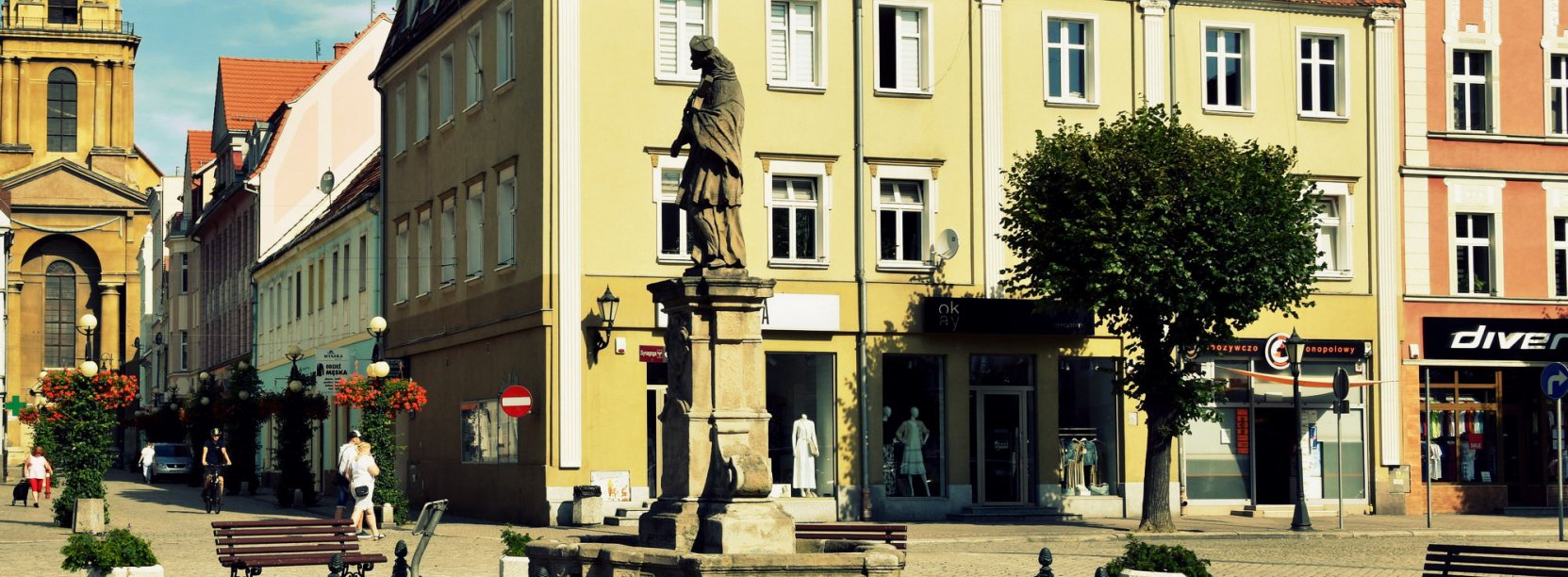 Widok pomnika św. Jana Nepomucena stającego w dzierżoniowskim rynku, w tle ul. Świdnicka