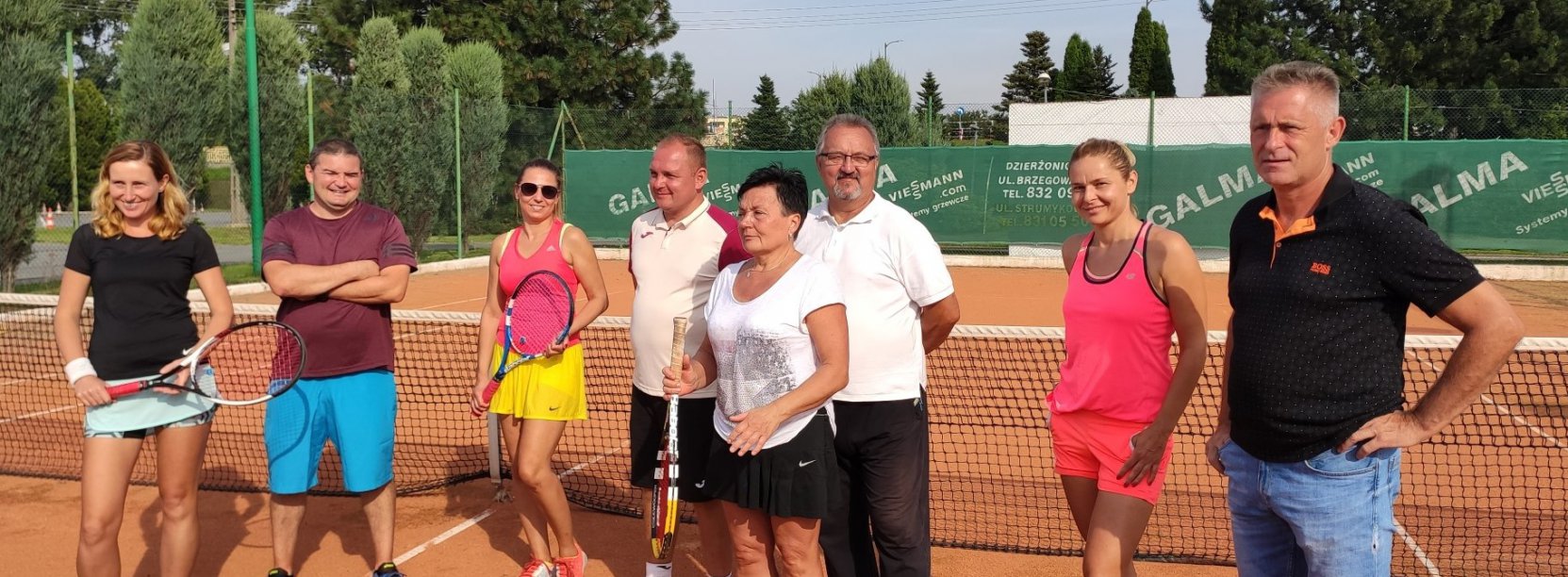 Ośmioro zawodników stojących na korcie tenisowym 