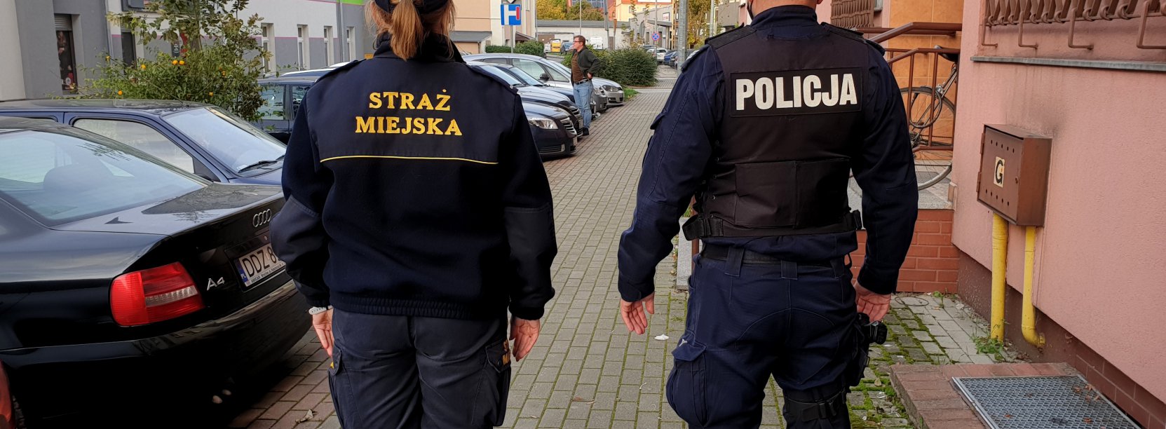 Strażnik miejski i policjant patrolujący razem ulice 