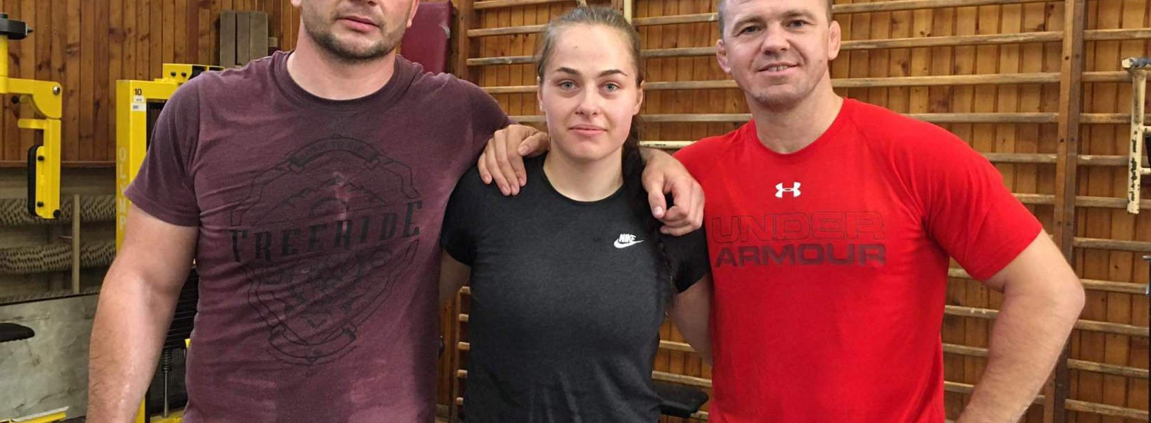 Karolina Kozłowska z wdoma trenerami w sali sportowej