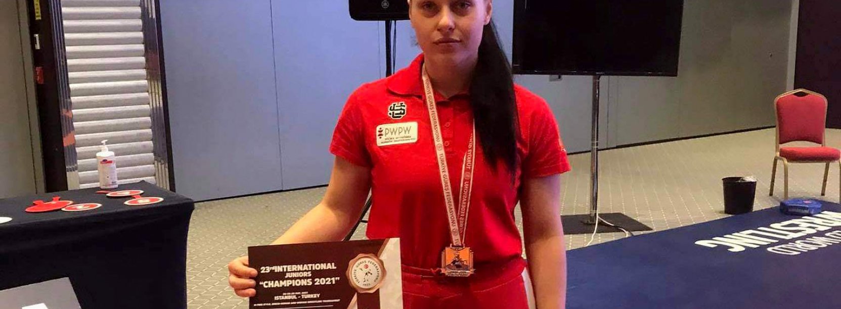 Dziewczyna w czerwonej koszylce ze sporowym trofeum w ręce