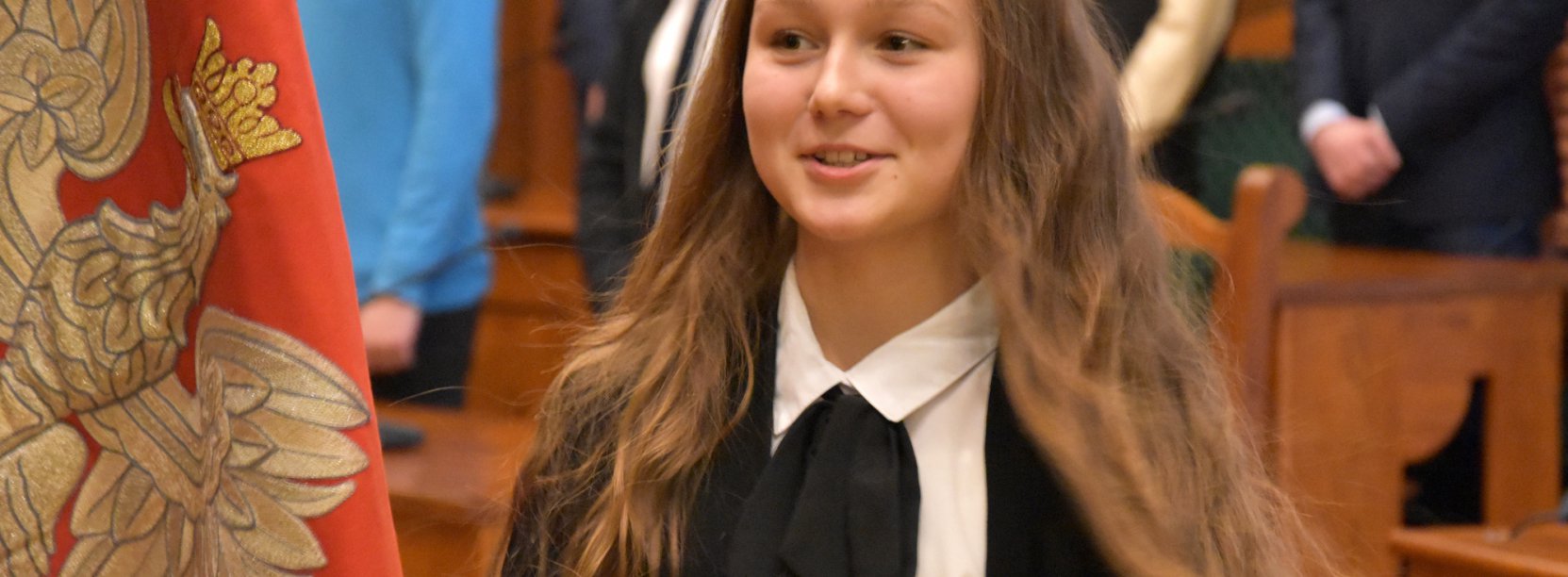 Usmiechnięta uczennica przy Godle Polski