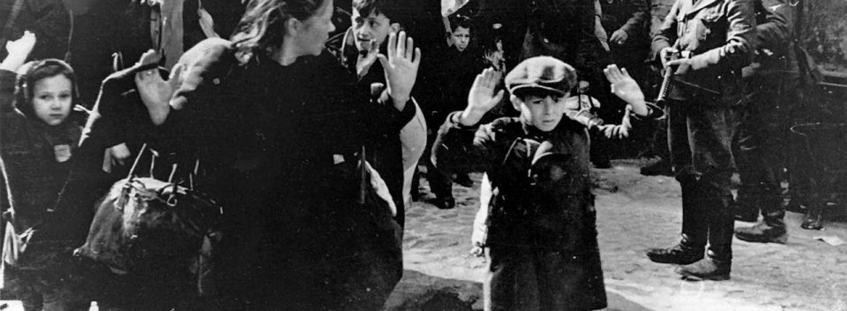 Zdjęcie archwiwalne, czarno-białe, przedstawia Żydów wypędzanych z mieszkań przez Niemców