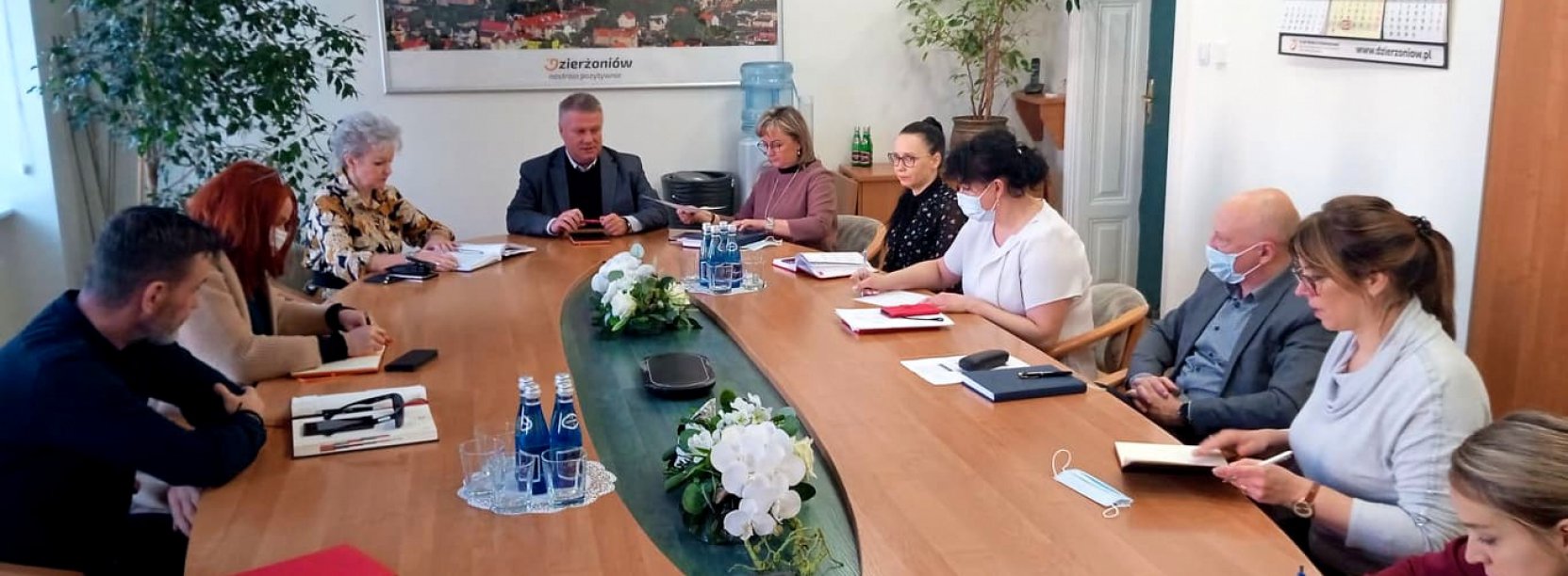 Ludzie siedzący przy dużym owalnym stole 