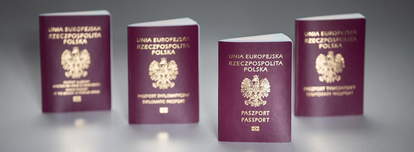 Cztery polskie paszporty, widok okładki, szare tło