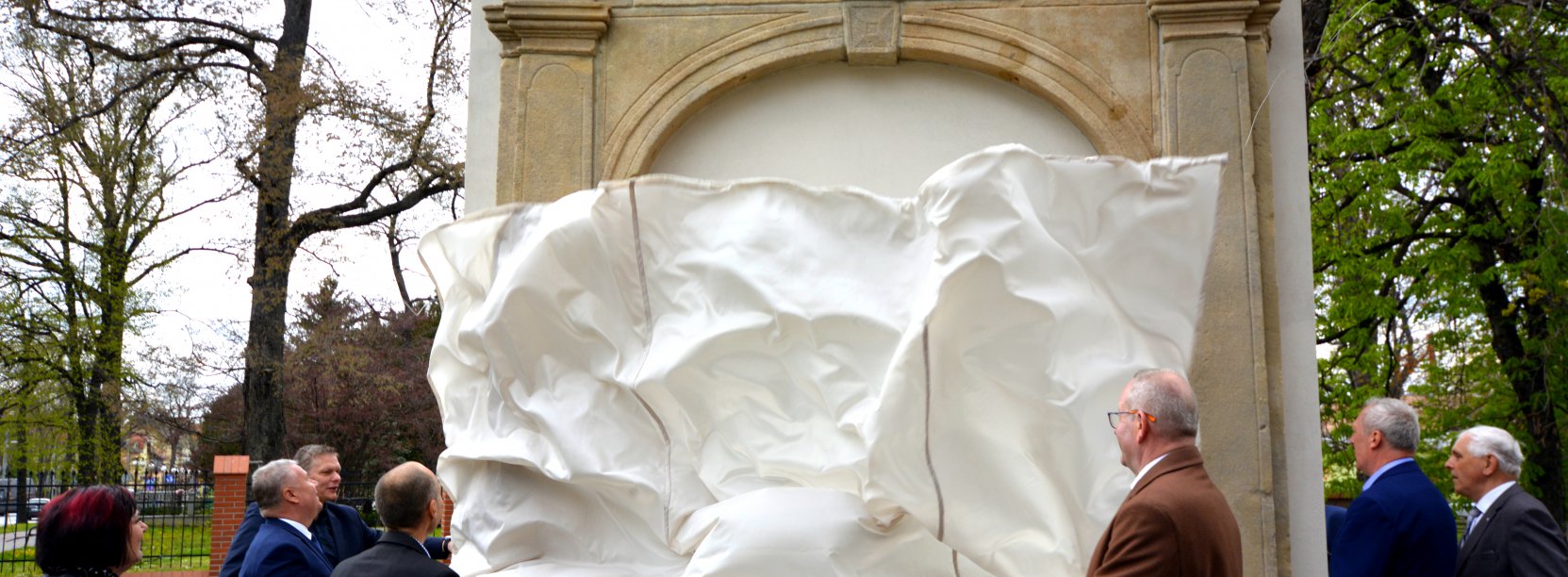 odsłonięcie barokowych portali w lapidarium przy muzeum miejskim, opadająca płachta białego matriału