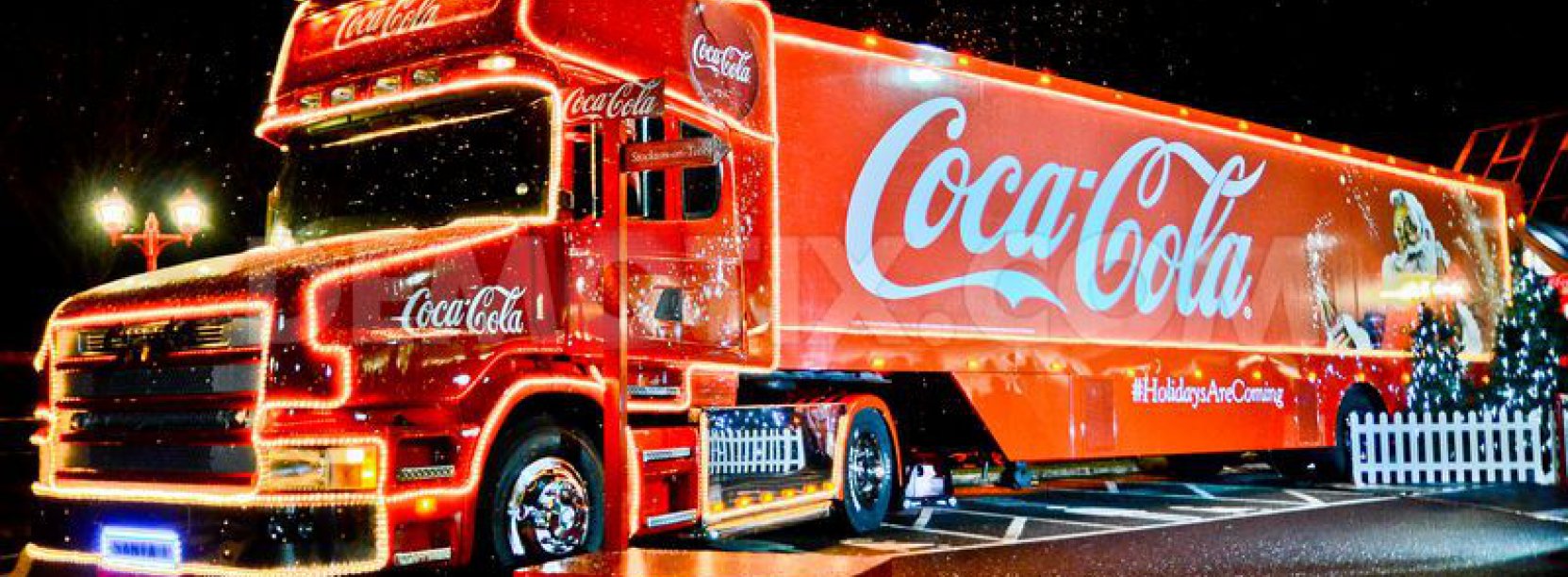 Duża czerwona ciężąrówka z napisem coca cola