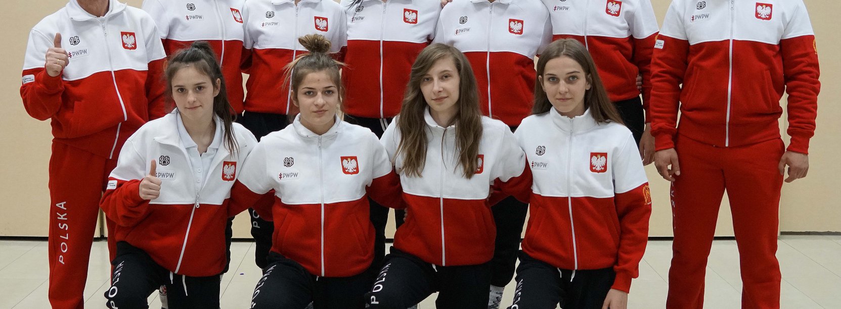 Grupa młodych osób ubrana w dresy w barwach flagi Polski 