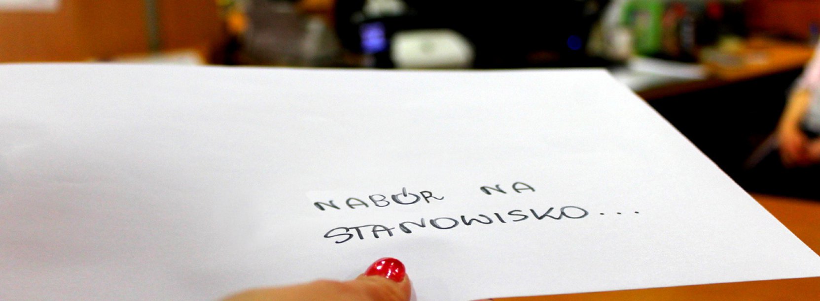 Dłoń trzymająca białą kopertę z napisem Nabór na stanowisko 