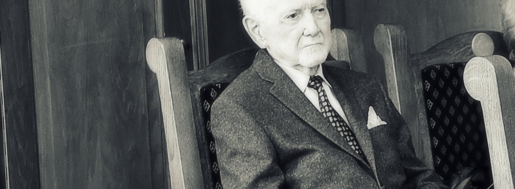 Czarno-białe zdjęcie starszego mężczyzny siedzącego na fotelu
