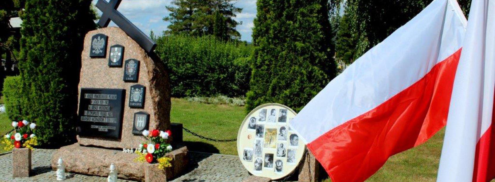 Kamienny obelisk na cmentarzu i flaga Polski