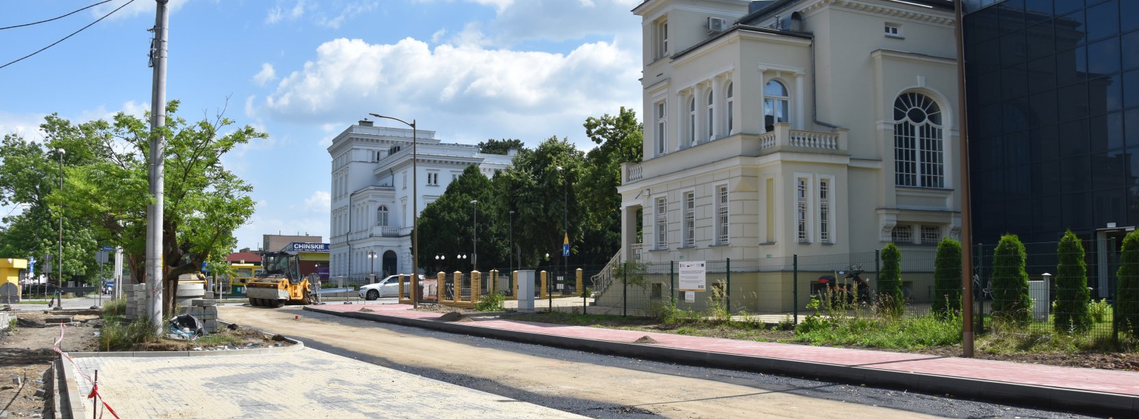 Droga w trakcie przebudowy, w tle wyremontowana kamienica