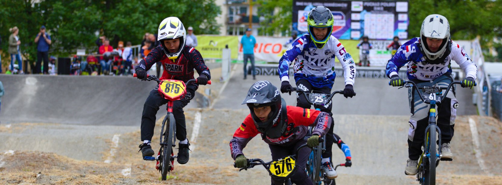 Czwórka młodych rowerzystów jadących po torze BMX