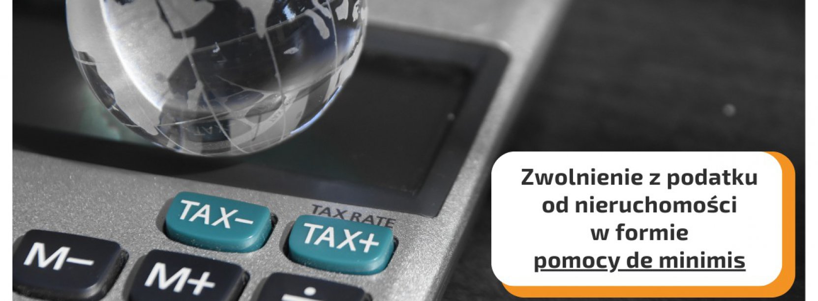 Kalkulator, na nim szklana kula przypominająca globus i napis Zwolnienie z podatku od nieruchomości