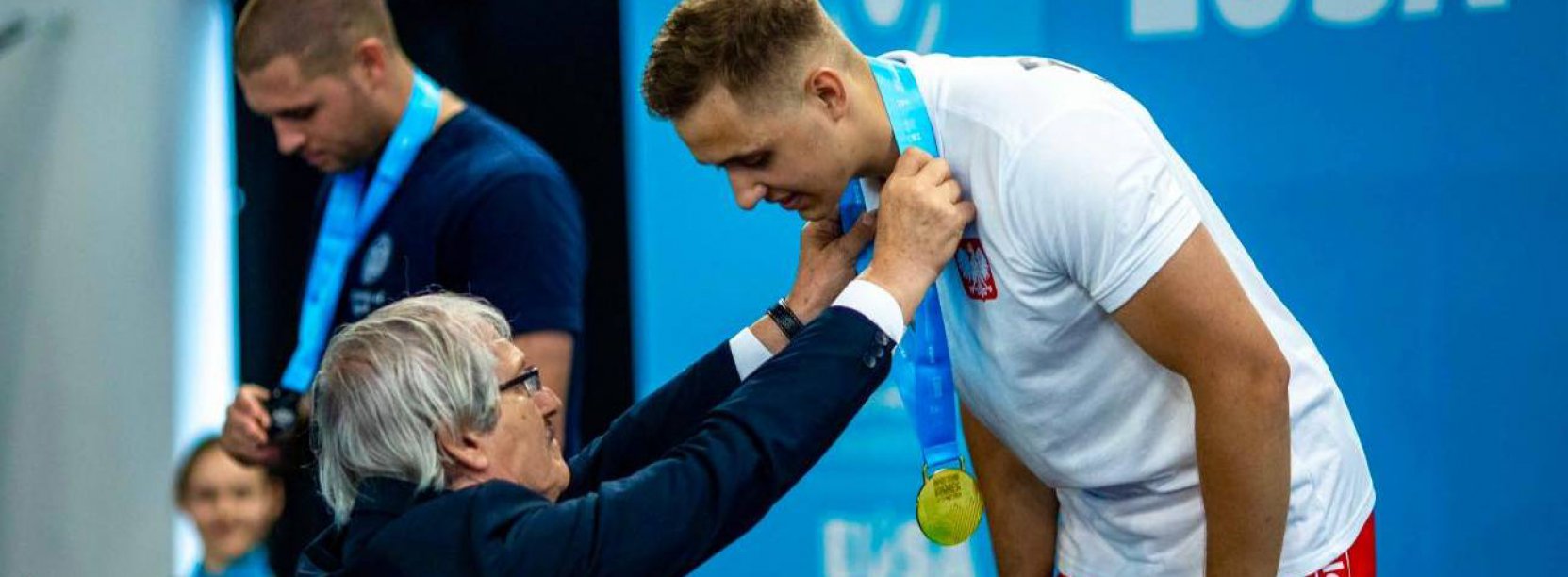 Zawodnik na podium przyjmuje złoty medal 