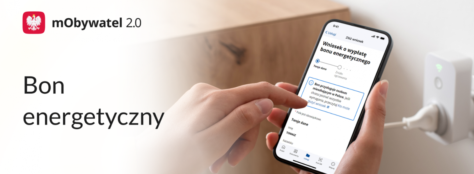 Dłonie trzymają telefon komórkowy, napis bon energetyczny, godło Polski, napis mObywatel 2.0
