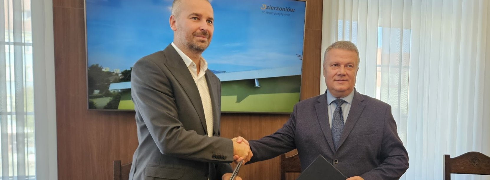 Z Lewej prof. Bartosz Kazimierczak, dziekan wydziału inżynierii środowiska, z prawej burmistrz Dariusz Kucharski, ściskają prawe dłonie po podpisaniu porozumienia między miastem a politechniką 