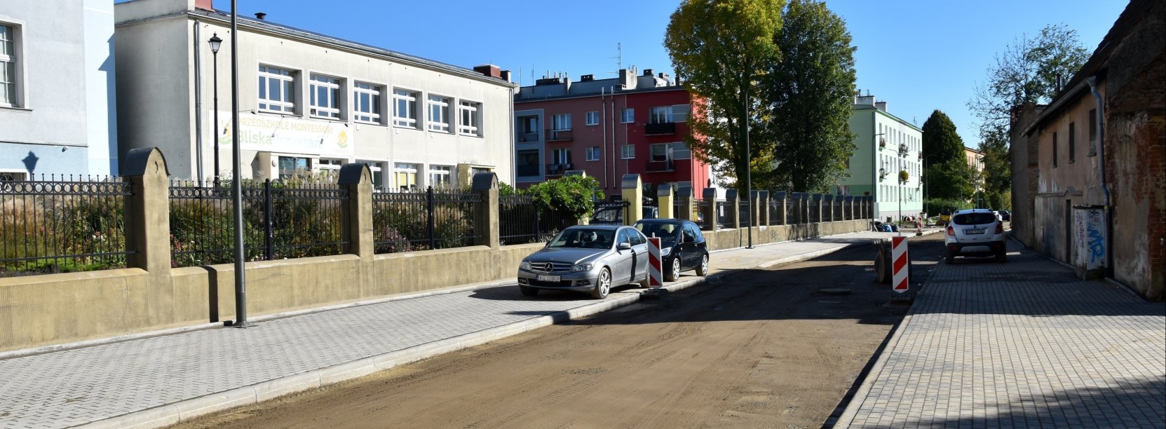 Droga w trakcie remontu, nowe chodniki z kostki betonowej, po bokach budynki