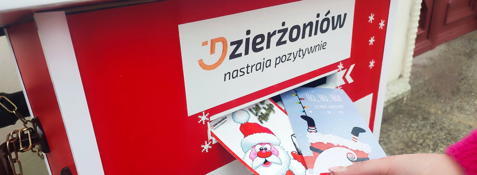 Czerwona skrzynka na listy i ręka wkładająća list, u góry napis Dzierżoniów