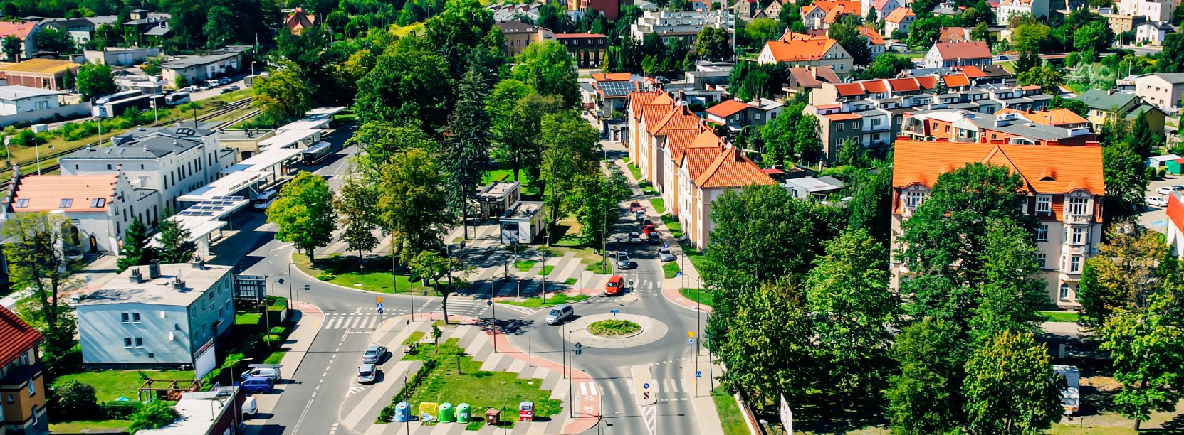 Fragment Dzierżoniowa z góry, dużo zieleni, parking i kamienice